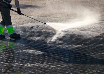 Wet cleaning of street with pressurized water.